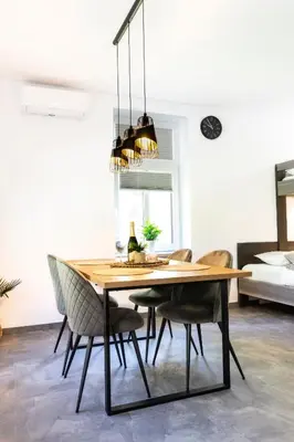 a dining room with a wooden table and chairs at Apartmaji na Pošti in Podsreda