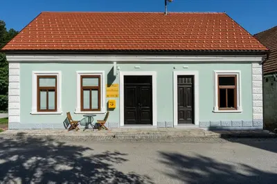 a small house with two chairs in front of it at Apartmaji na Pošti in Podsreda