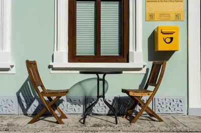 two chairs and a table and a window at Apartmaji na Pošti in Podsreda