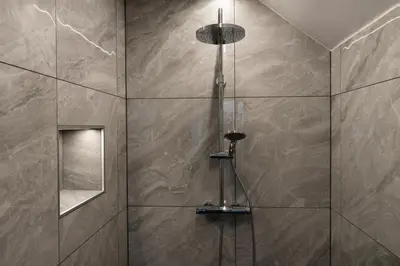 a bathroom with a shower with a glass door at Apartmaji na Pošti in Podsreda