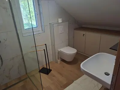 a bathroom with a toilet and a glass shower at APARTMA BriGITA in Gorica pri Slivnici