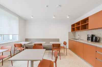 an office with tables and chairs and a kitchen at Prenočišča AUTUR in Tolmin
