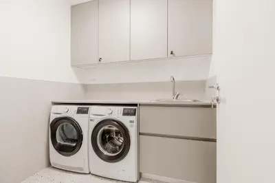 a white kitchen with a washing machine and a sink at Prenočišča AUTUR in Tolmin