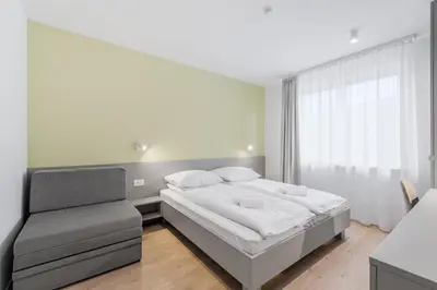a bedroom with a bed and a chair at Prenočišča AUTUR in Tolmin