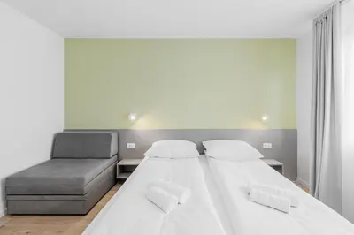 a bedroom with two beds and a couch at Prenočišča AUTUR in Tolmin