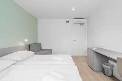 a white room with a bed and a desk at Prenočišča AUTUR in Tolmin