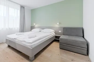 a bedroom with a large bed and a chair at Prenočišča AUTUR in Tolmin