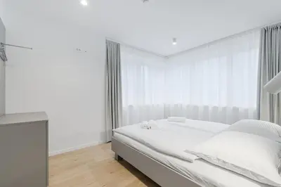 a white bedroom with a bed and a window at Prenočišča AUTUR in Tolmin