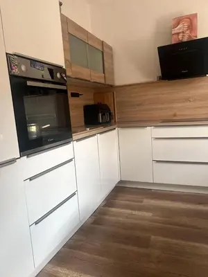 a kitchen with white cabinets and a microwave at City soul duplex apartment in Maribor