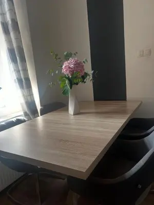 a vase of flowers sitting on a wooden table at City soul duplex apartment in Maribor
