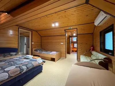 a room with two beds in a log cabin at Apartma ob Kolpi Križan in Gradac