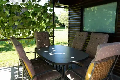 a table and chairs on a screened in porch at Apartma ob Kolpi Križan in Gradac