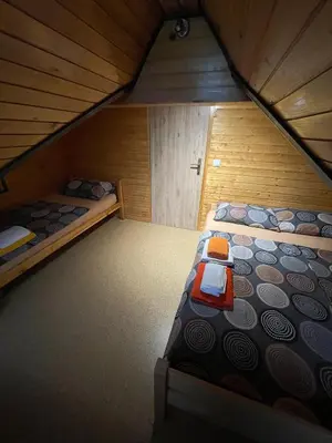 an attic bedroom with two beds in a cabin at Apartma ob Kolpi Križan in Gradac