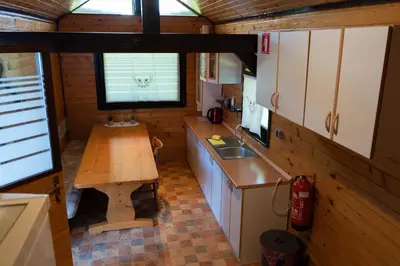 a small kitchen with a wooden table and a sink at Apartma ob Kolpi Križan in Gradac