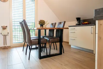 a kitchen with a table and four chairs at Apartma Urška in Bohinj