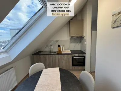 a kitchen with a dining table and a large window at Citybase Rooms in Ljubljana