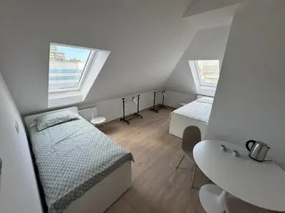 a small room with two beds and a sink at Citybase Rooms in Ljubljana