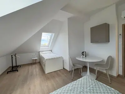 a room with a table and a bed and a window at Citybase Rooms in Ljubljana