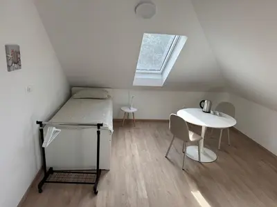 a small room with a bed and a table at Citybase Rooms in Ljubljana