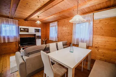 a living room with a table and a couch at Log Cabin Vista View with Seasonal Hot Tub in Bizeljsko