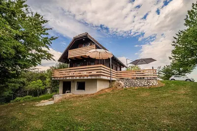 a house with an umbrella on top of a hill at Log Cabin Vista View with Seasonal Hot Tub in Bizeljsko