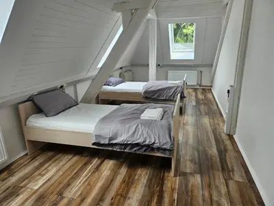 two beds in a room with wooden floors at hostel Toper in Celje