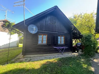 a small house with a black roof at Ferienhaus Čatež Holzhaus an der Therme Čatež in Brežice