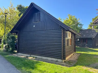 a small brown building with a black roof at Ferienhaus Čatež Holzhaus an der Therme Čatež in Brežice