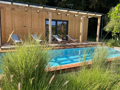 a swimming pool with chairs and a house at Pri Mimiki - Luxury Country House & Spa near the Wine Road in Kamnica
