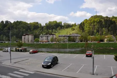 a parking lot with cars parked in front of a hill at Hiša Elsbacher Laško in Laško