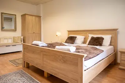 a bedroom with a large wooden bed with two pillows at Hiša Elsbacher Laško in Laško