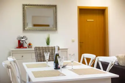 a white dining room table with a bottle of wine at Hiša Elsbacher Laško in Laško