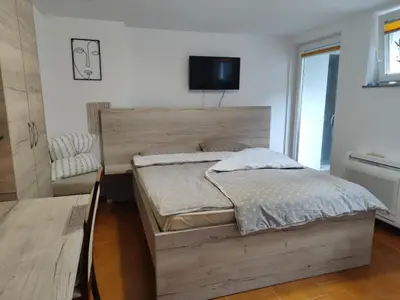 a bedroom with a bed and a tv on the wall at Apartma Lastovka in Moravske Toplice