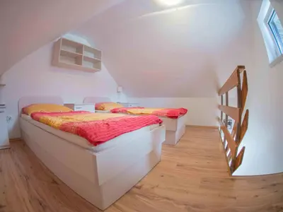 two beds in a room with a staircase at Apartment Šmon in Kranjska Gora