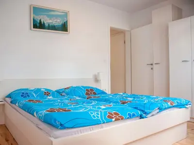 a bed in a bedroom with a blue comforter at Apartment Šmon in Kranjska Gora