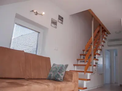 a living room with a couch and a staircase at Apartment Šmon in Kranjska Gora