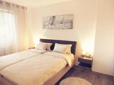 a bedroom with a large bed with white sheets at ONYX Apartments in Ljubljana