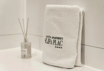 a white towel sitting on a counter next to a vase at Lipa Plac in Postojna