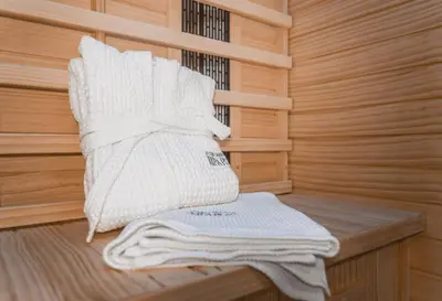 a sauna with white towels sitting on a wooden bench at Lipa Plac in Postojna