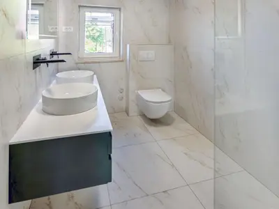 a white bathroom with a sink and a toilet at Apartment Adelsberg Inn-1 by Interhome in Postojna