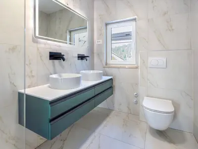 a bathroom with a sink and a toilet and a mirror at Apartment Adelsberg Inn-1 by Interhome in Postojna