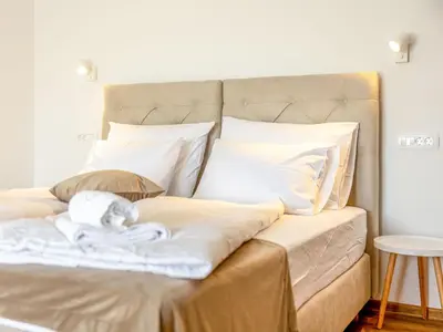 a bed with white sheets and a stuffed animal on it at Apartment Adelsberg Inn-1 by Interhome in Postojna