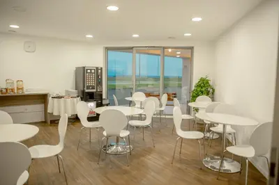 a dining room with white tables and white chairs at Garni Hotel Krško in Leskovec pri Krškem