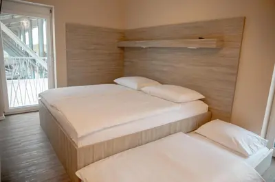 two twin beds in a room with a window at Garni Hotel Krško in Leskovec pri Krškem