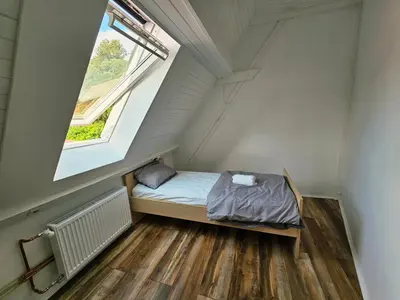 a small bed in a room with a window at Hostel pod gradom in Celje