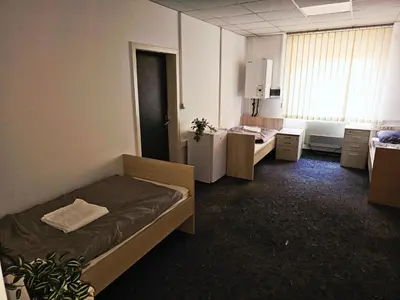 a small room with two beds and a window at Hostel pod gradom in Celje