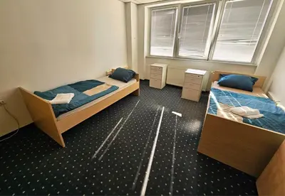 a bedroom with two beds and a window at Hostel pod gradom in Celje