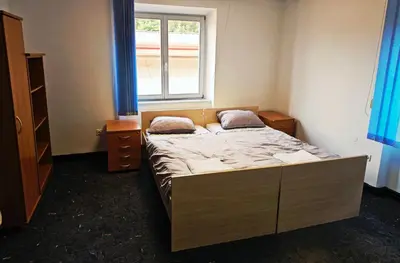 a small bedroom with a bed and a window at Hostel pod gradom in Celje