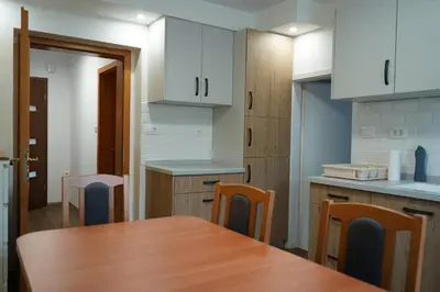 a kitchen with a wooden table and chairs at Apartma Mlinca 1 in Mojstrana