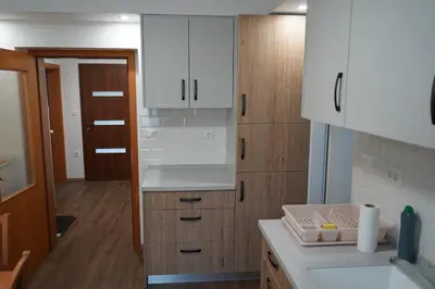 a kitchen with white cabinets and a counter top at Apartma Mlinca 1 in Mojstrana